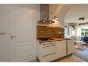 a kitchen with a stove and a white door at Apartment in Zoutelande near the Beach in Zoutelande +16 photos