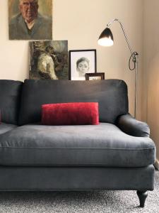 a couch with a red pillow on it in a living room at Affordable 5-bed family home overlooking the popular West Park in Wolverhampton