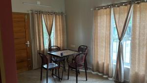 a table and chairs in a room with a window at Vintage Coffee Premium Villa in Pinangode