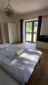 a bedroom with a large bed and a large window at Chalupa ve Svinné in Svinná