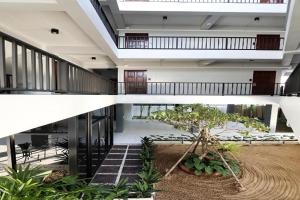 un grand bâtiment avec un arbre dans une cour dans l'établissement Hotel Wualai by CMStay, à Chiang Mai