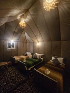 a room with two beds in a tent at Luxury Desert Queen Camp in Merzouga