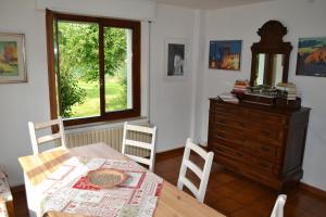 a dining room with a table and a dresser and a window at Ka' Tari in Ponte nellʼAlpi