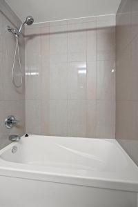 een douche in een badkamer met een wit bad bij Modern 1Bd & Den Condo with Balcony Lillian St in Toronto +12 foto's