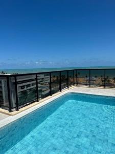 ein Swimmingpool mit Blick auf das Meer in der Unterkunft Home service cabo branco varanda vista parcial in João Pessoa