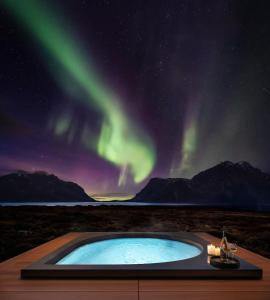 una piscina con la aurora en el cielo en Secluded Lodge - Stunning Views!, en Storøya
