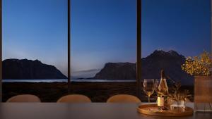 una mesa con copas de vino y vistas a las montañas en Secluded Lodge - Stunning Views!, en Storøya
