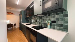 a kitchen with black cabinets and green tiles at Gontim Boutique Stay in Viana do Castelo