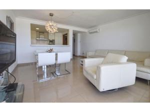 a living room with a white couch and a table at Harborfront Escape in Mallorca in Can Picafort +14 photos