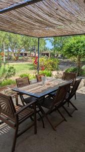 a wooden table and chairs under an umbrella at Agroturismo Finca Sant Blai in Campos