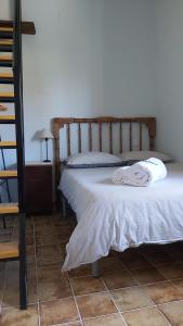 a bedroom with a bed with a wooden headboard at Casa Rural Mar de Encinas in Cabañas del Castillo