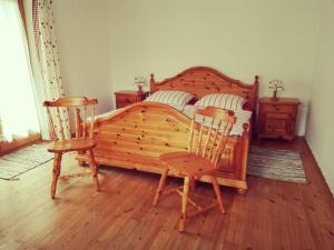 a bedroom with a wooden bed and two chairs at Ferienhaus Anni in Warngau