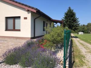 a house with a fence and flowers in front of it at Spa Apartmán Kováčová in Kováčová