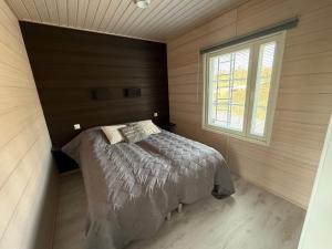 a bedroom with a bed in a room with a window at Villa Hile - 8 hengen mökki, rauhallinen sijainti Himoksen ytimessä in Jämsä