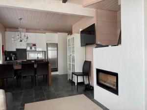 a kitchen and dining room with a table and a fireplace at Villa Hile - 8 hengen mökki, rauhallinen sijainti Himoksen ytimessä in Jämsä