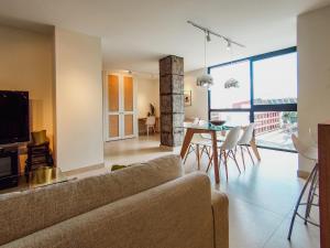 a living room with a couch and a table with chairs at Luminoso piso con vistas privilegiadas. in Santa Cruz de Tenerife