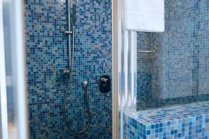 a bathroom with a shower with a blue tiled wall at Residence Millecento in Cesenatico +117 photos