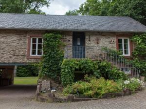 an old stone house with ivy growing on it at Mosel Mill Garden Stay in Maring-Noviand