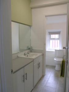 サウス・シールズにあるWinchester Street Apartmentの白いバスルーム(洗面台、トイレ付)