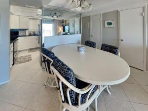 a kitchen and dining room with a white table and chairs at Barry Palm in Ormond Beach