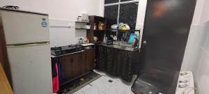 a small kitchen with a sink and a refrigerator at Tuaran 88 Homestay in Tuaran