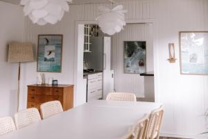a kitchen with a white table and chairs at Kommahuset in Ervik