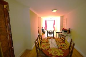 a dining room with a table and chairs with pizzas on it at 3 Bed Family House and Garden in Hanworth
