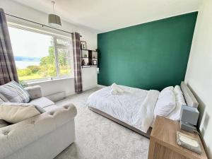 une chambre avec un mur végétal, un lit et un canapé dans l'établissement Avenue Cottage, Inveraray, à Inveraray