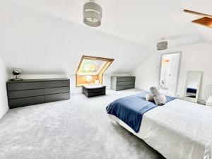 une chambre blanche avec un lit et une fenêtre dans l'établissement Avenue Cottage, Inveraray, à Inveraray