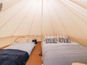 two beds in a canvas tent with at Bell 2 in Cirencester