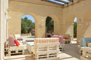 a patio with chaise lounge chairs and arches at Agriturismo Masseria San Leonardo in Savelletri di Fasano