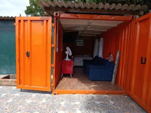 an orange house with a blue couch in it at Made in Roça in Piedade