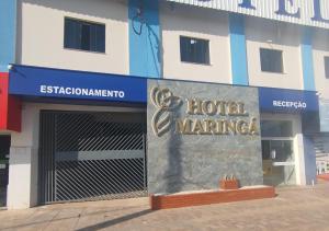 una entrada al hotel con una señal frente a un edificio en Hotel Maringá, en Juara
