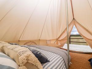 a bedroom with a tent with a bed in it at Bell 3 in Cirencester