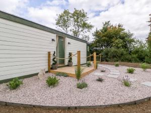 a garden with a wooden deck next to a building at Bell 3 in Cirencester +11 photos
