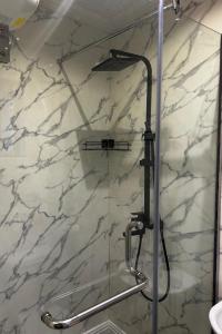a shower in a bathroom with a marble wall at Molo Apartments in Lekki +5 photos
