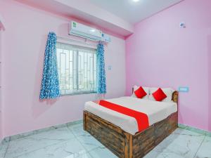 a bedroom with a bed and a window at Hotel O Kalinga Inn in Bhubaneshwar