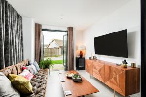 a living room with a couch and a flat screen tv at Minety Lake 07 Lower Mill Estate The Cotswolds in Somerford Keynes