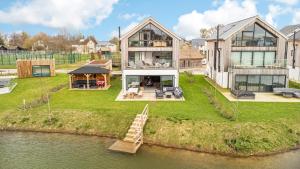 a large house on an island in the water at Minety Lake 07 Lower Mill Estate The Cotswolds in Somerford Keynes