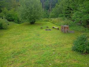 a grassy field with a bench and a picnic table at Przystanek Wetlina in Wetlina