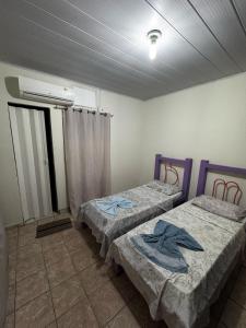 a room with two beds in a room at Casa do Marcus in Barra do Garças