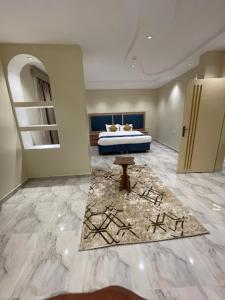a bedroom with a bed and a rug in a room at Dani Serviced Apartments in Buqayq
