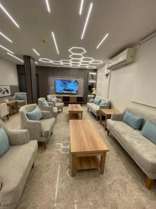 a waiting room with couches and a flat screen tv at Dani Serviced Apartments in Buqayq