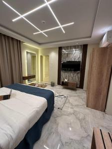 a bedroom with a large bed in a room with marble floors at Dani Serviced Apartments in Buqayq