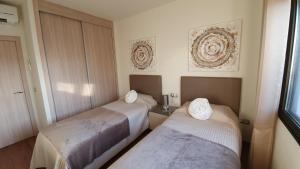 two beds in a hotel room with towels on them at Villa BELLA on Golf in La Estancia, Caleta Fuste-Fuerteventura in Caleta De Fuste +36 photos