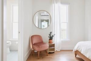 a white bedroom with a chair and a mirror at Sardar house in Rāwala Kot