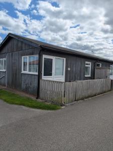 ein Holzhaus mit einem Zaun davor in der Unterkunft ElE G Holiday let's Bridlington in Bridlington