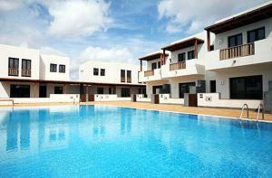 a large swimming pool in front of a building at Residencial Noray Duplex 26 in Puerto Calero