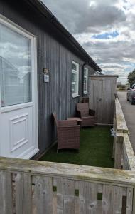 eine Veranda mit Stühlen und einem Tisch auf einem Haus in der Unterkunft ElE G Holiday let's Bridlington in Bridlington