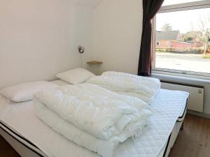 a white bed in a room with a window at 6 person holiday home in Hadsund in Hadsund